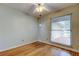 Bright bedroom featuring hardwood floors, a ceiling fan, and a window with neighborhood views at 16403 Bonneville Dr, Tampa, FL 33624