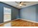 A bedroom featuring a ceiling fan and hardwood flooring showcases a bright atmosphere at 16403 Bonneville Dr, Tampa, FL 33624