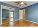 Bedroom features a ceiling fan, hardwood floors, closet, and a white paneled door at 16403 Bonneville Dr, Tampa, FL 33624
