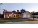 Exterior view of the home at night with beautifully lit landscaping at 16403 Bonneville Dr, Tampa, FL 33624