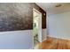 Hallway leading to bathroom features hardwood floors and stylish wall texture at 16403 Bonneville Dr, Tampa, FL 33624
