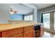 Wet bar with wood cabinets, wine refrigerator, and access to the outdoor pool area at 16403 Bonneville Dr, Tampa, FL 33624