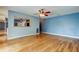 Spacious living room featuring wood laminate flooring, ceiling fan, and passthrough to the kitchen at 16403 Bonneville Dr, Tampa, FL 33624