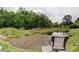 Relaxing backyard view of a lush pond with a seating area and natural surroundings at 16403 Bonneville Dr, Tampa, FL 33624