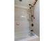 A bathroom shower head sits atop a white tiled tub surround at 16403 Bonneville Dr, Tampa, FL 33624
