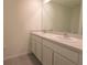 Bright bathroom featuring a double sink vanity and a large mirror at 16805 Delia St, Wimauma, FL 33598