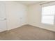 Bright bedroom with neutral carpet, white walls, and a window allowing natural light at 16805 Delia St, Wimauma, FL 33598