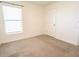 A neutral bedroom with a carpet, white walls, and a window that lets natural light at 16805 Delia St, Wimauma, FL 33598