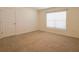 Bedroom with neutral carpet, window, and door at 16805 Delia St, Wimauma, FL 33598