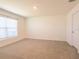 Bedroom with neutral carpet, window, and door at 16805 Delia St, Wimauma, FL 33598