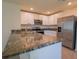 Modern kitchen features stainless steel appliances, granite countertops, and white cabinetry at 16805 Delia St, Wimauma, FL 33598