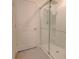 Bathroom featuring a tiled shower with glass doors, and a white door at 16805 Delia St, Wimauma, FL 33598