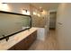 Bathroom with dual vanities, a large mirror, and a glass-enclosed shower with tiled walls at 18051 Foxtail Loop, Venice, FL 34293
