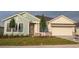 Charming single-story home showcasing a two-car garage, manicured lawn, and inviting front entrance at 18051 Foxtail Loop, Venice, FL 34293