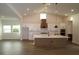Bright open kitchen featuring an island, pendant lighting, white cabinets, and stainless steel appliances at 18051 Foxtail Loop, Venice, FL 34293