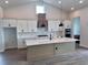 A modern kitchen featuring white cabinetry, a center island with countertop, and stainless steel appliances at 18051 Foxtail Loop, Venice, FL 34293