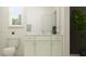 Well-lit bathroom featuring a white vanity with marble countertop, silver hardware, and a plant for decor at 18448 Serene Lake Loop, Lutz, FL 33548