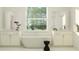 Bright bathroom features a soaking tub, dual sinks, and a large window at 18448 Serene Lake Loop, Lutz, FL 33548