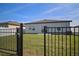 View of the backyard featuring a well-maintained lawn with an iron fence at 2232 Harris Hawk, Ruskin, FL 33570