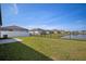 Spacious backyard featuring a well-maintained lawn with an iron fence overlooking a scenic pond at 2232 Harris Hawk, Ruskin, FL 33570