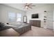 Bright bedroom with ceiling fan, dresser with television, and large windows for natural light at 2232 Harris Hawk, Ruskin, FL 33570