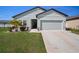 Inviting single-Gathering home with a two-car garage, lush green lawn, and vibrant landscaping at 2232 Harris Hawk, Ruskin, FL 33570