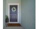 Welcoming front door adorned with a floral wreath and a charming 'Home Sweet Home' doormat at 2232 Harris Hawk, Ruskin, FL 33570