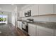 Well-equipped kitchen featuring stainless steel appliances, granite countertops, and modern white cabinetry at 2232 Harris Hawk, Ruskin, FL 33570