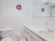 Bathroom with white tiled walls, round mirror and commode at 2348 Shelley St # 2, Clearwater, FL 33765