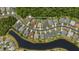 An aerial view displays the property's layout in relation to surrounding houses, green spaces and a pond at 26920 Winged Elm Dr, Wesley Chapel, FL 33544
