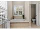 Bathroom features a soaking tub, plantation shutters and an adjacent toilet room at 26920 Winged Elm Dr, Wesley Chapel, FL 33544