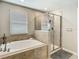 Bright bathroom featuring a soaking tub, a glass-enclosed shower, and modern fixtures at 28642 Tranquil Lake Cir, Wesley Chapel, FL 33543