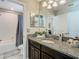Granite vanity top with dual sinks in this well-lit bathroom with tub-shower combo at 28642 Tranquil Lake Cir, Wesley Chapel, FL 33543