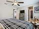 Bedroom with a plaid comforter, wood dresser, and attached bathroom providing a private retreat at 28642 Tranquil Lake Cir, Wesley Chapel, FL 33543