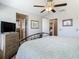 Bedroom featuring a neutral color palette, natural wood dresser, and multiple entryways to a connected ensuite at 28642 Tranquil Lake Cir, Wesley Chapel, FL 33543