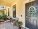 A quaint front porch with comfortable seating and decorative plants by the entrance at 28642 Tranquil Lake Cir, Wesley Chapel, FL 33543
