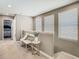 Cozy upstairs hallway with decorative seating, neutral tones, and natural light from nearby windows at 28642 Tranquil Lake Cir, Wesley Chapel, FL 33543