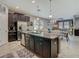 Open kitchen with granite island, stainless steel appliances, dark cabinetry, and chandelier lighting at 28642 Tranquil Lake Cir, Wesley Chapel, FL 33543
