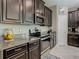 Modern kitchen featuring granite countertops, stainless steel appliances, and dark wood cabinets at 28642 Tranquil Lake Cir, Wesley Chapel, FL 33543