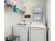 Bright laundry room with modern washer and dryer, plus overhead storage shelves at 28642 Tranquil Lake Cir, Wesley Chapel, FL 33543