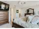 Bright and airy main bedroom with large dresser, decorative accents, and comfortable king-sized bed at 28642 Tranquil Lake Cir, Wesley Chapel, FL 33543
