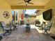 Cozy covered patio boasts stylish seating, ceiling fan, and stone fire pit at 28642 Tranquil Lake Cir, Wesley Chapel, FL 33543