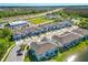 Aerial view of an attractive community with a pond, modern townhomes, and convenient parking at 2895 Deer Pine Trl, Land O Lakes, FL 34638