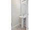 Modern powder room featuring a pedestal sink, oval mirror, and neutral color scheme at 2895 Deer Pine Trl, Land O Lakes, FL 34638