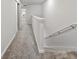Upstairs hallway with carpet and stairs, showcasing the home's layout at 2895 Deer Pine Trl, Land O Lakes, FL 34638