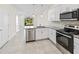 Bright kitchen with stainless steel appliances, granite counters, and an open view to backyard at 2895 Deer Pine Trl, Land O Lakes, FL 34638