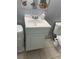 Bathroom sink with chrome fixtures, white cabinetry, and a decorative mirror at 2910 Lichen Ln # B, Clearwater, FL 33760