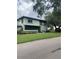 View of the home exterior with a screened-in porch, green lawn, and mature tree, creating curb appeal at 2910 Lichen Ln # B, Clearwater, FL 33760
