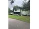 Two-story home showcasing its exterior with a charming screened-in porch and well-maintained landscaping at 2910 Lichen Ln # B, Clearwater, FL 33760
