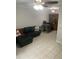 Living room with a dark sofa, tile flooring, and a work space in background at 2910 Lichen Ln # B, Clearwater, FL 33760